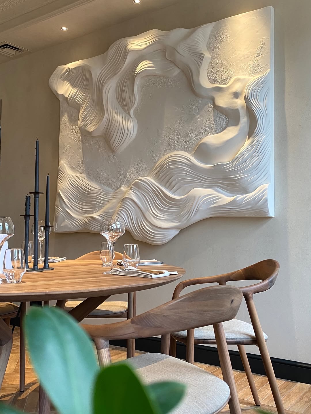 Bridge, a sculpted wall relief installed above a dining table at MOST restaurant.
